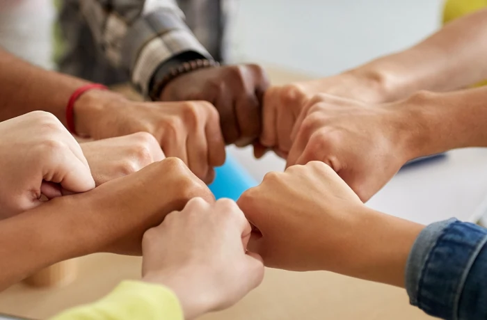 Mãos conectadas de punhos fechados.