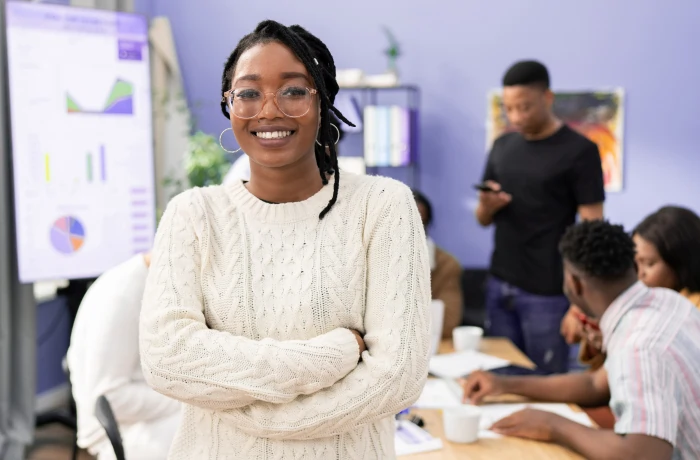 Pessoas em sala planejando estratégias em quadro branco.